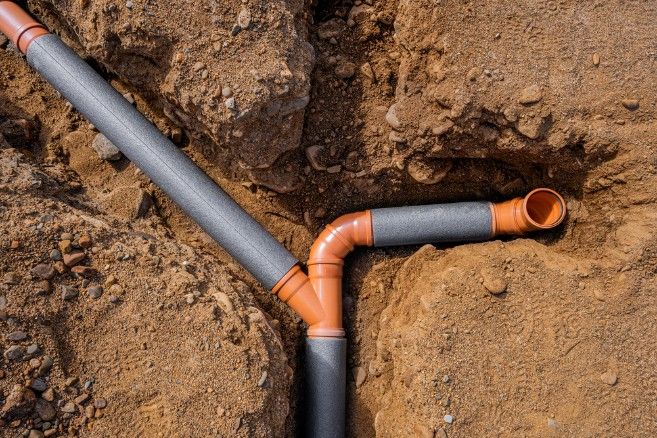 A Couple of Pipes Are Connected to Each Other in the Dirt — Kerney Plumbing in Bacchus Marsh, VIC