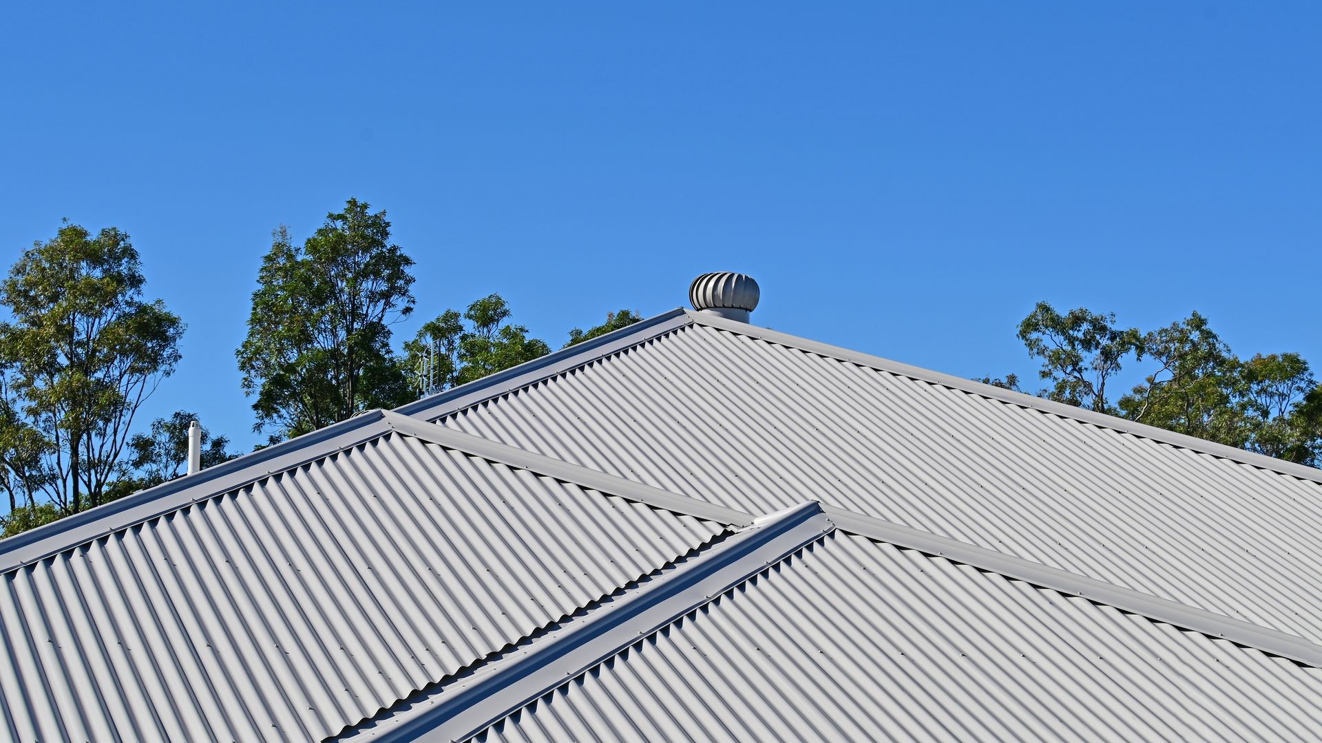 Blue sky behind a metal roof with a whirlybird — Kerney Plumbing in Bacchus Marsh, VIC