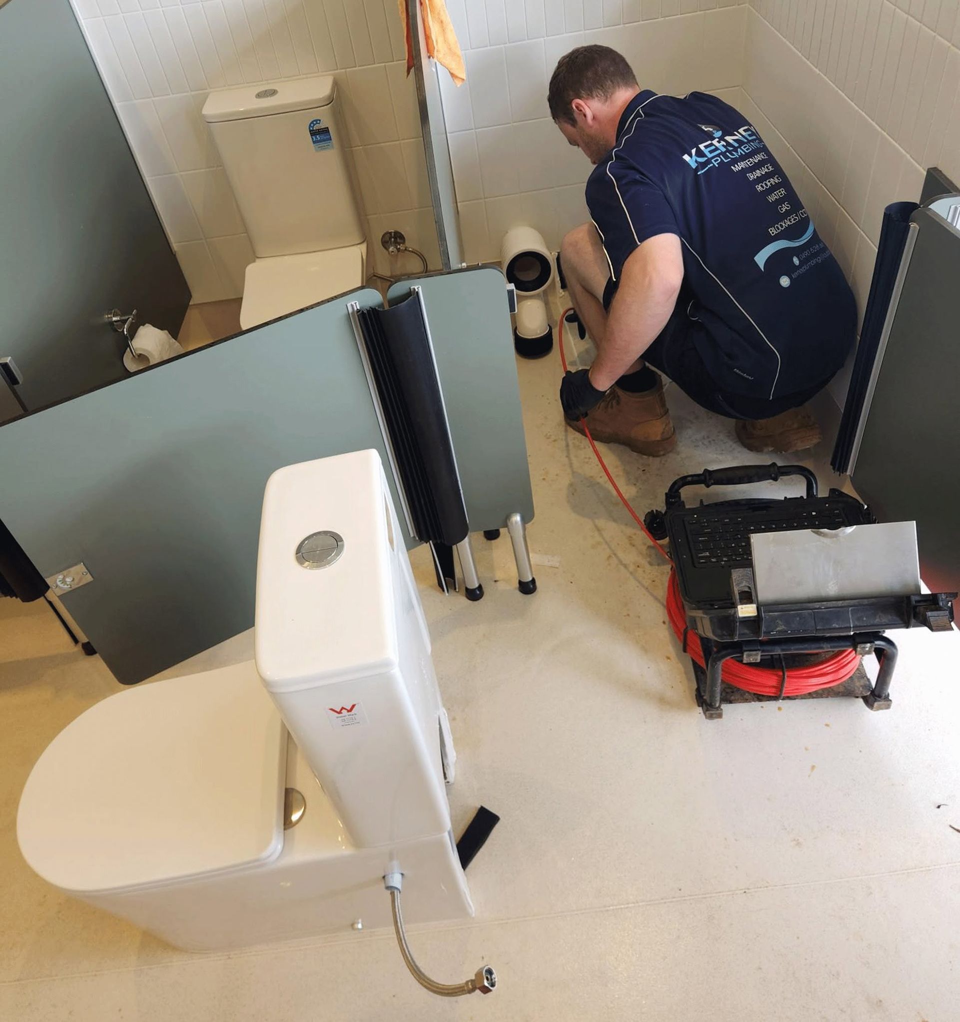 Man Installing Bathroom Equipment Beside a Toilet in a Small, Unfinished Bathroom — Kerney Plumbing in Ballarat, VIC