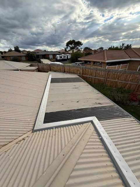 Rooftop With Corrugated Metal Panels and a Skylight, Under Cloudy Skies in a Suburban Neighborhood — Kerney Plumbing in Ballarat, VIC