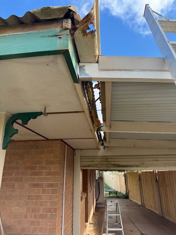 Damaged Roof Edge With a Narrow Gap Between Two Building Overhangs Under a Blue Sky — Kerney Plumbing in Melton, VIC
