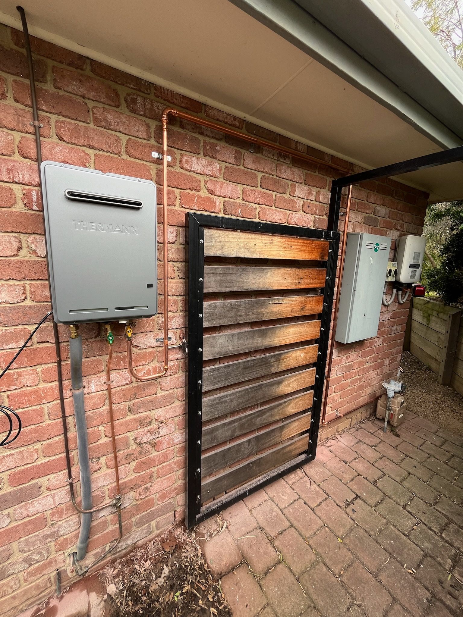 A Person is Fixing a Pipe With a Screwdriver in a Bathroom — Kerney Plumbing in Melton, VIC
