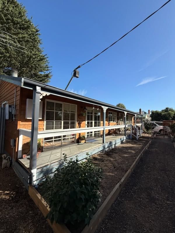 Single-storey Home With a Covered Front Veranda, Timber Exterior, and Garden Bed Under a Clear Blue Sky— Kerney Plumbing in Bacchus Marsh, VIC