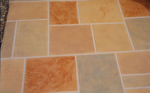 Tiled floor with various shades of beige, orange, and gray, separated by white grout.