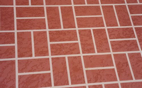 Red and beige brick patio with rectangular blocks and mortar lines.