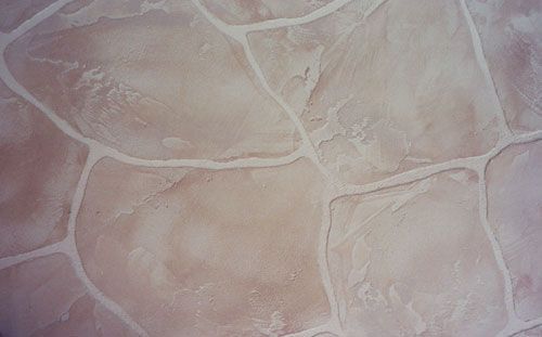 Tan, stone-like flooring with light grout lines.