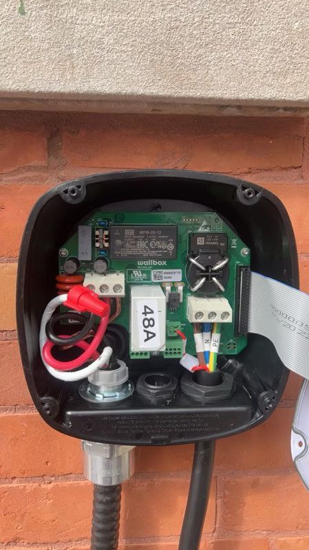 A close up of a electrical box on a brick wall.