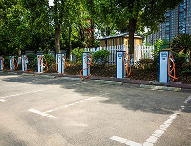 A row of electric vehicle charging stations in a parking lot.