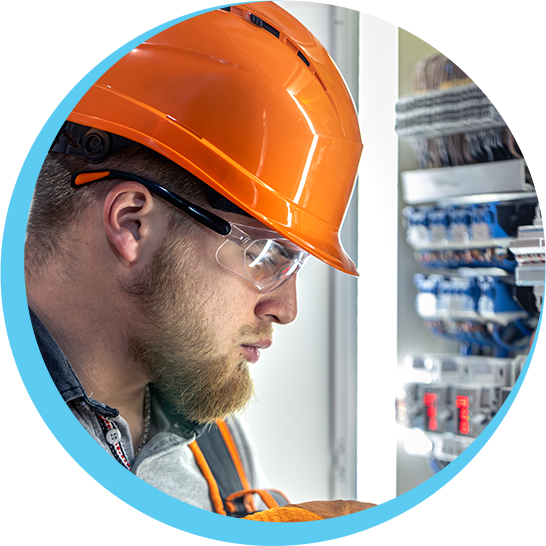 A man wearing an orange hard hat and safety glasses