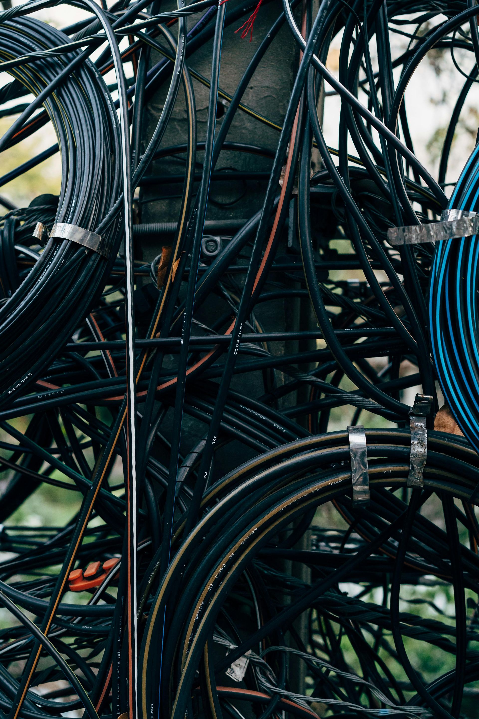 A bunch of wires are stacked on top of each other on a pole.