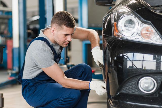 a man is working on a car in a garage .