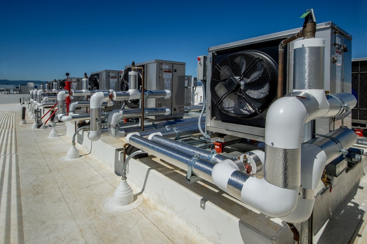 A rooftop with a lot of pipes and fans on it