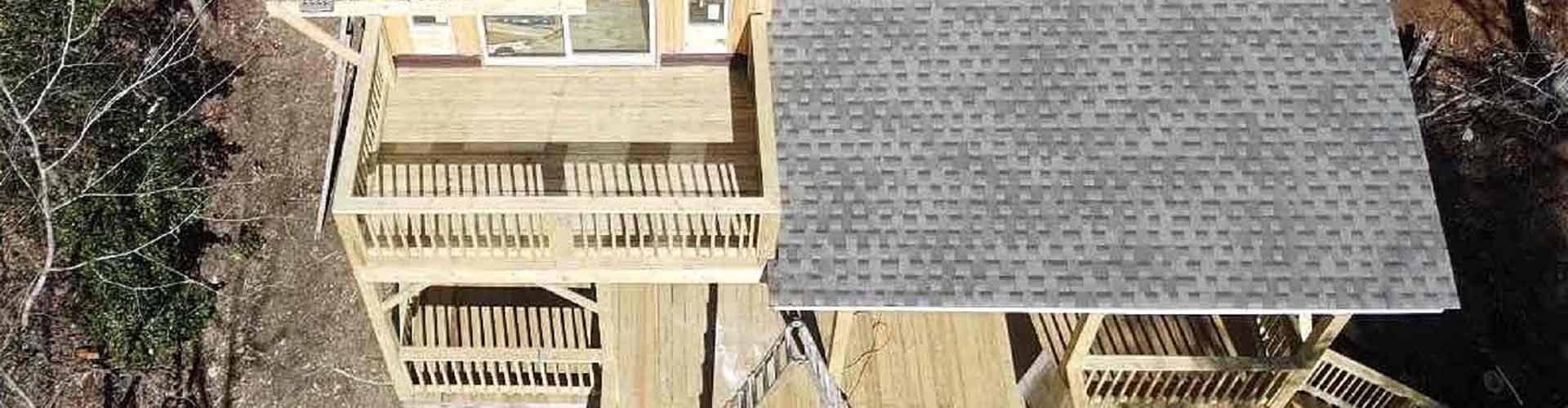 Overhead view of a wooden deck with a gray-shingled roof.