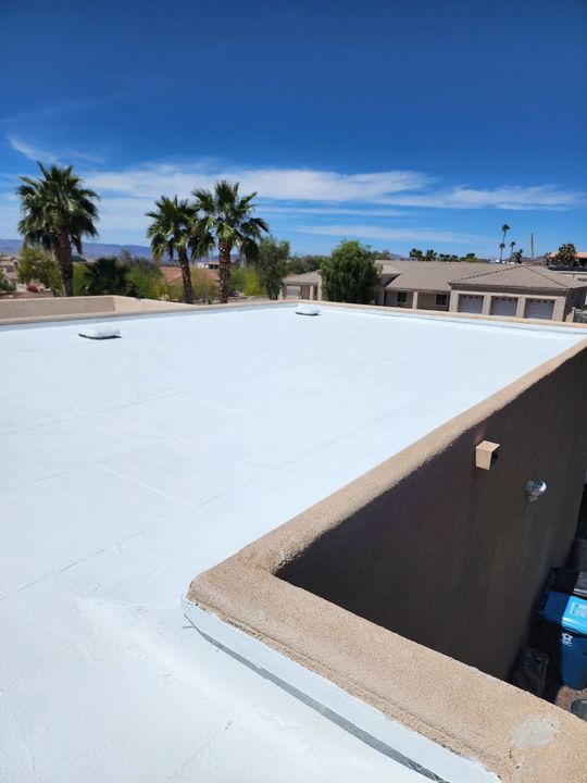 the roof of a brick house with a gray roof and a blue sky in the background