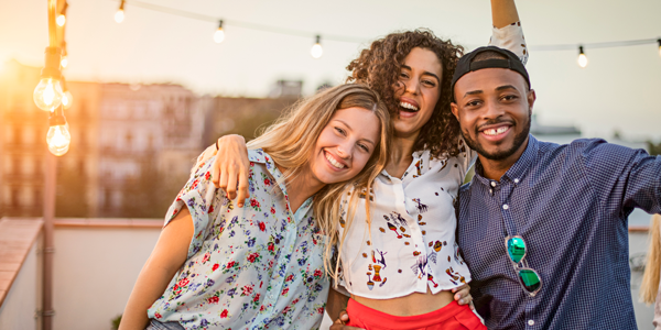 A group of young people are posing for a picture on a rooftop.