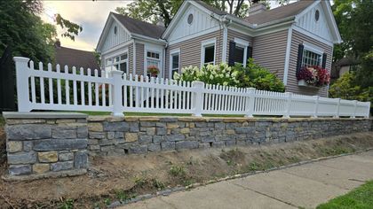 A person is using a drill to install a wooden fence. A person is using a drill to install a wooden fence.