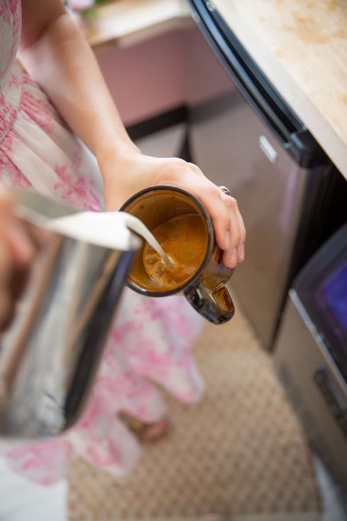 Espresso in cup with a barista pouring steamed milk into the cup to create a latte