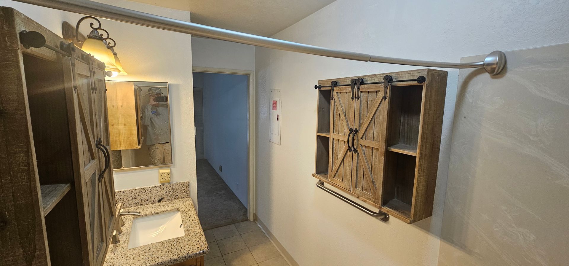 A bathroom with a sink , mirror and sliding barn doors.