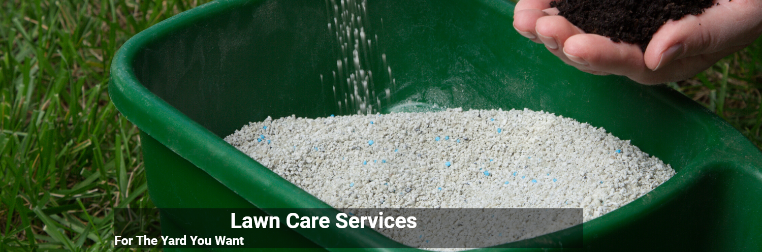 A hand holds dark soil over a green plastic spreader filled with granular fertilizer pellets, advertising lawn services.