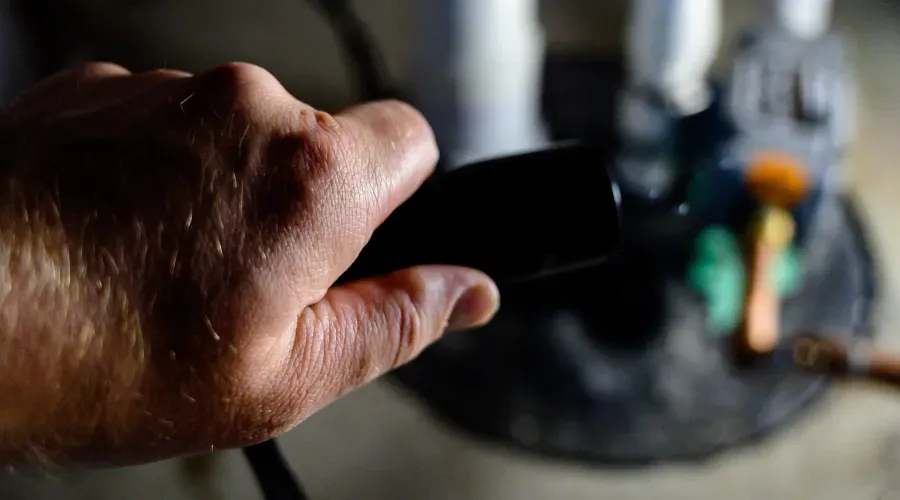 A close up of a person 's hand holding a black object.