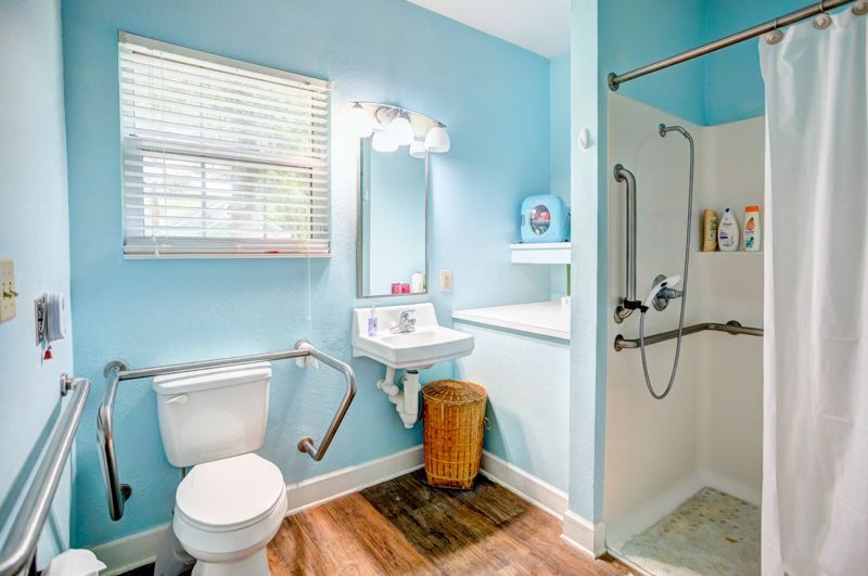A bathroom with a toilet , sink , and shower.