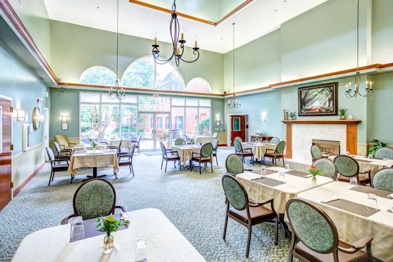 A large dining room with tables and chairs and a fireplace.