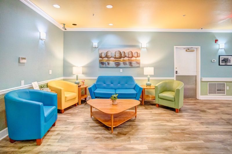 A living room with a couch , chairs , and a coffee table.