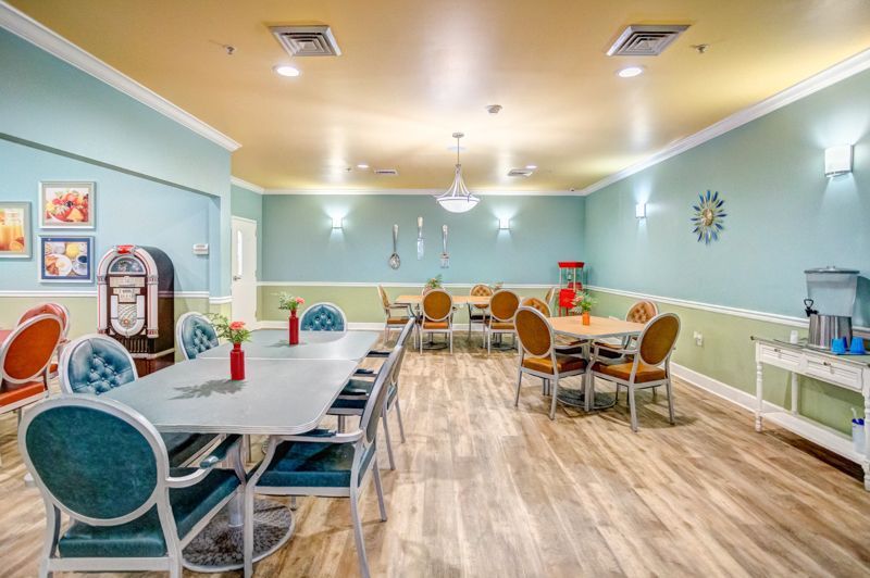 A large dining room with tables and chairs and a jukebox.