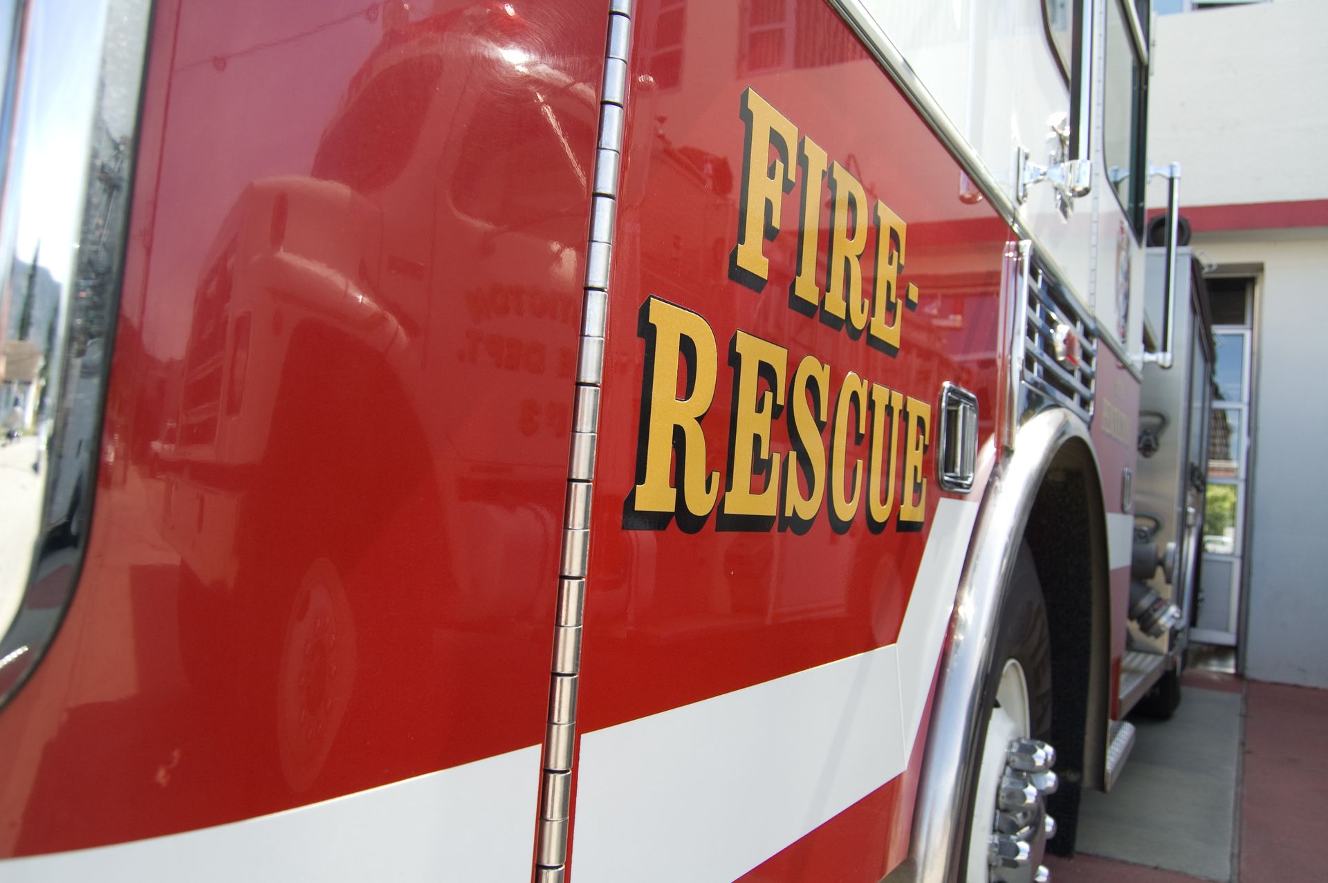 A red fire rescue truck is parked in front of a building
