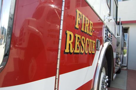 A red fire rescue truck is parked in front of a building