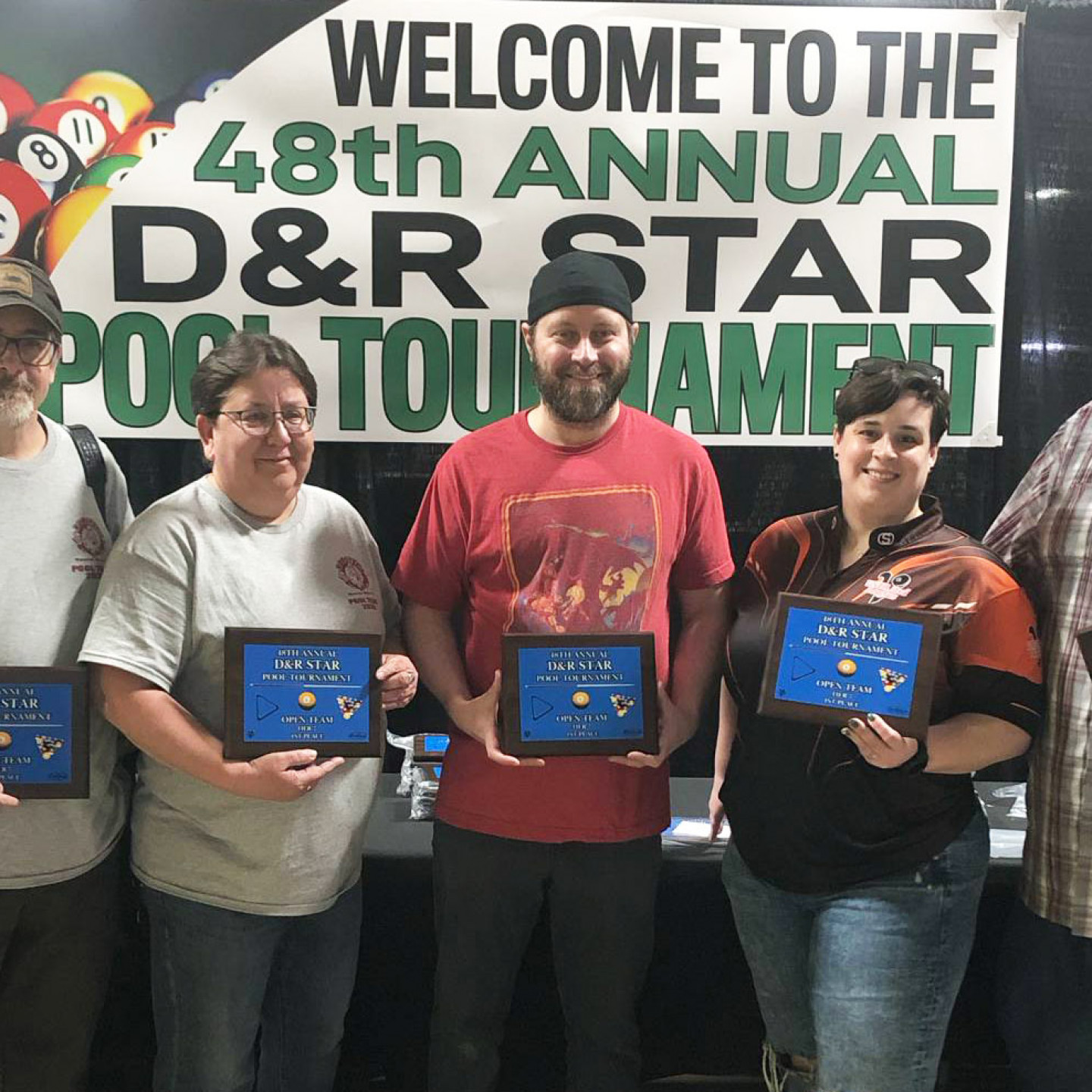 People holding plaques at the 48th Annual D&R Star Pool Tournament. Sign behind them.