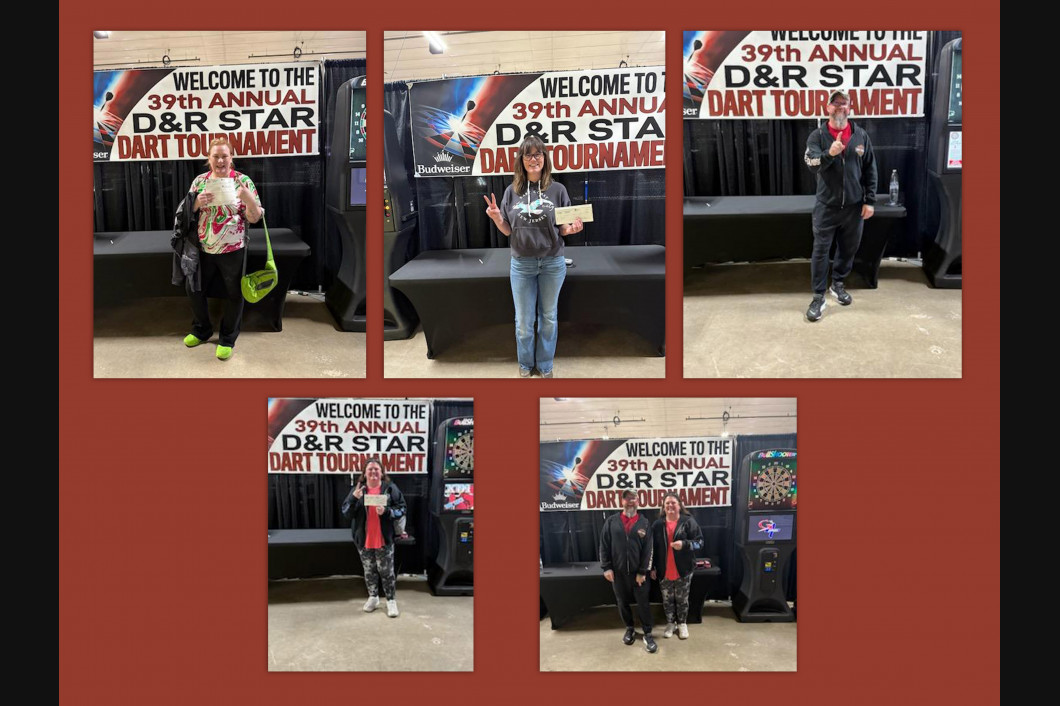 People at a dart tournament, in front of a banner that says 