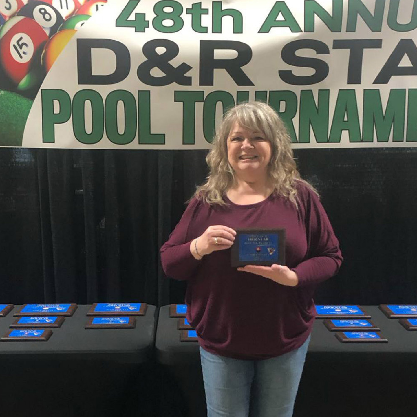 Woman holding a trophy at the 48th Annual D&R Star Pool Tournament.