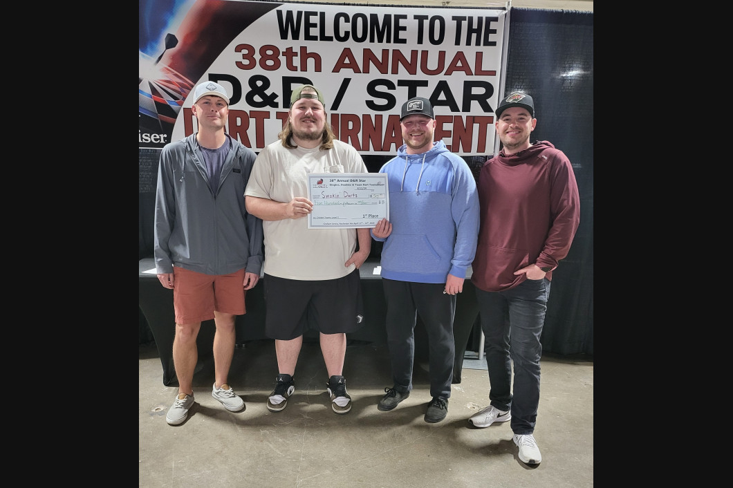 Four people standing in front of a banner that says 