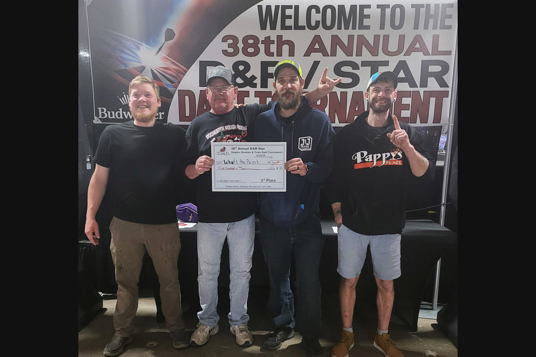 Four men holding a check, smiling, at the 38th Annual D&V/Star Dart Tournament.