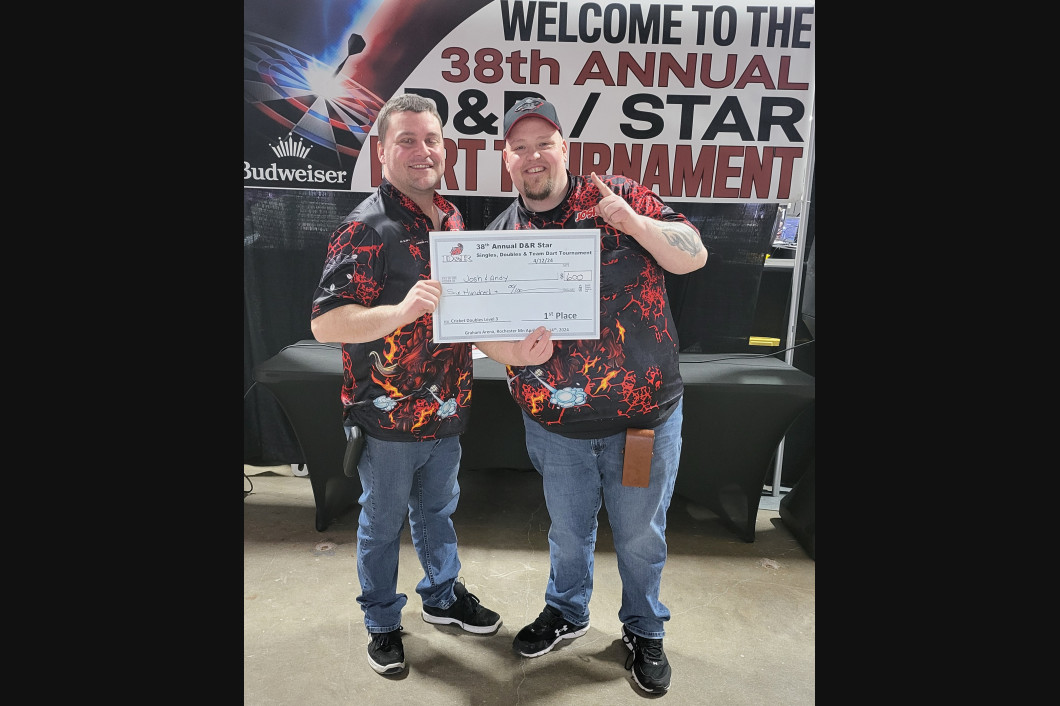 Two men holding a large check at the 38th Annual D&R/STAR Dart Tournament.
