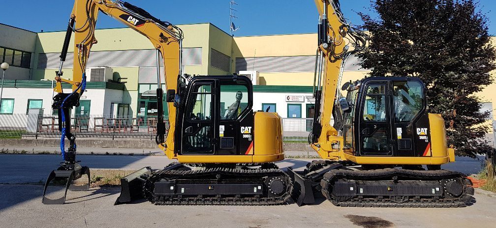 Due escavatori Caterpillar gialli parcheggiati all'aperto.