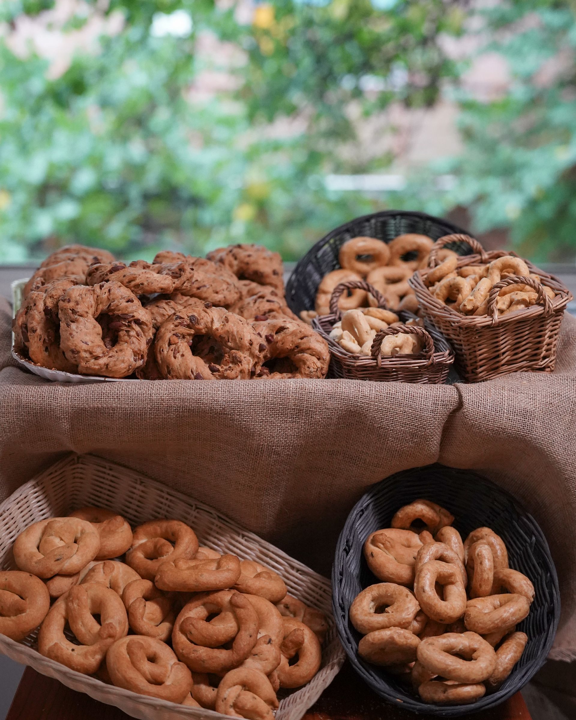 Persona che tiene in mano un contenitore di plastica trasparente contenente pasticcini, sei biscotti cilindrici con le estremità ricoperte di cioccolato.