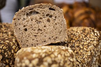 Mano che tiene un sacchetto di plastica sigillato con all'interno una grande fetta di pane tostato.