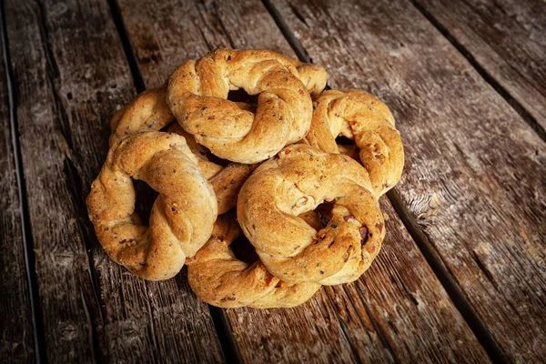 Mano che regge un sacchetto di taralli su una bancarella del mercato. Sono visibili altri prodotti da forno e un carrello elevatore.
