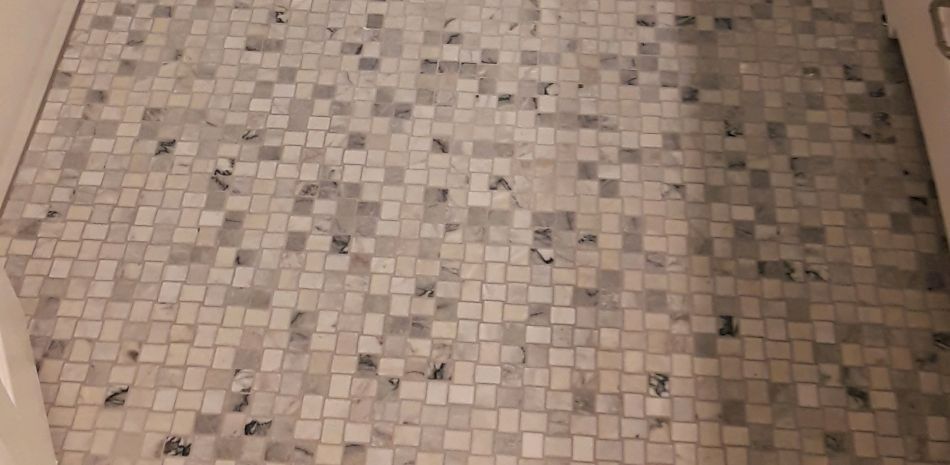 Beige tiled floor with a small decorative pattern and a wall edge on the right