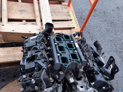 Black engine sitting on a wooden pallet, viewed from above. | Lains Auto Service