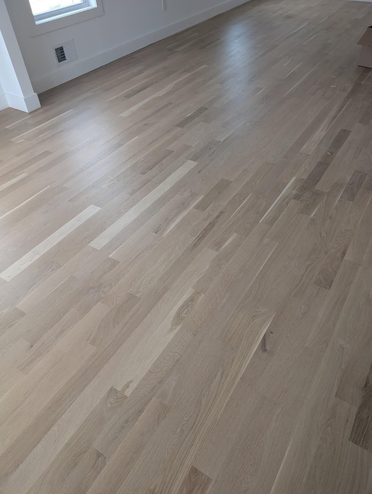 Empty room with light wood flooring and white walls