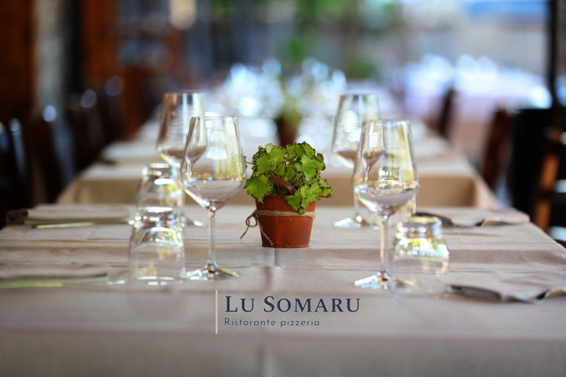 un tavolo in un ristorante con bicchieri di vino e una pianta in vaso .