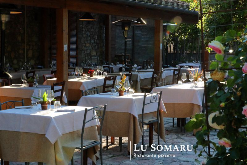 un ristorante con molti tavoli e sedie è chiamato lu somaru