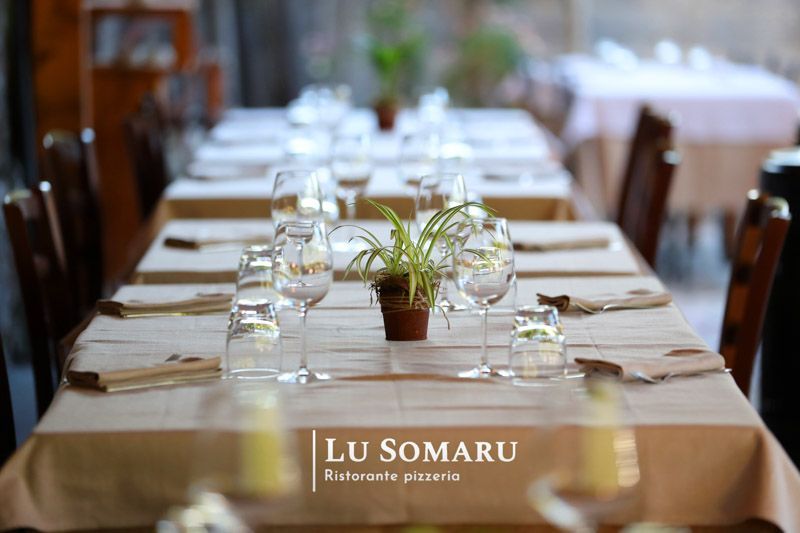 un lungo tavolo con bicchieri e tovaglioli in un ristorante