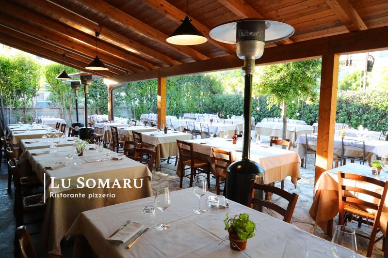 un ristorante con molti tavoli e sedie è chiamato lu somaru