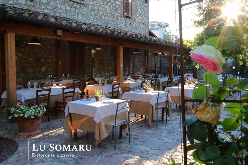 un ristorante con tavoli e sedie è chiamato lu somaru