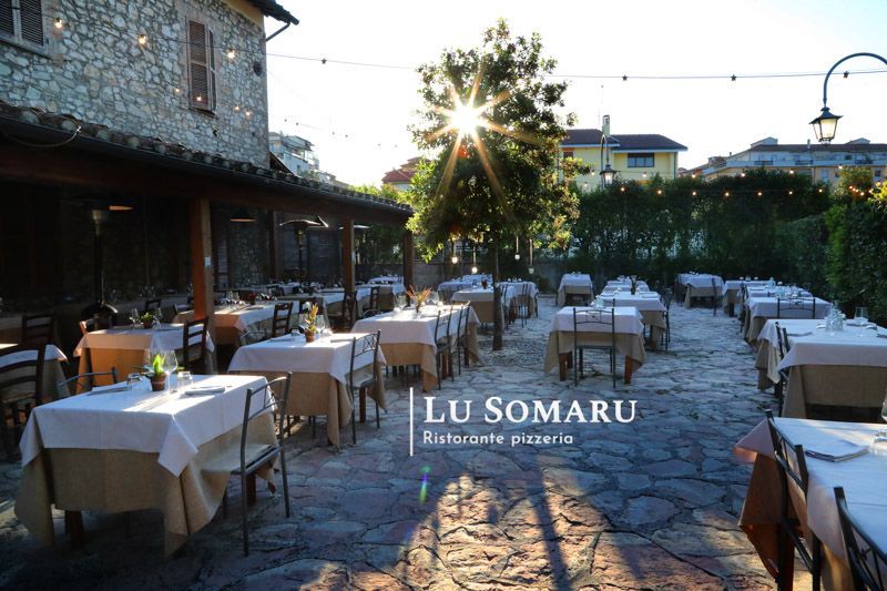 un ristorante con molti tavoli e sedie è chiamato lu somaru