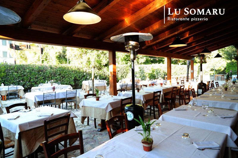 un ristorante con molti tavoli e sedie è chiamato lu somaru